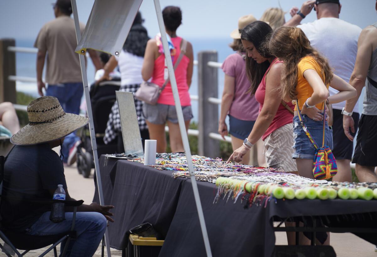Street vendors sell their wares along the sidewalk around Ellen Browning Scripps Park in La Jolla in late July.
