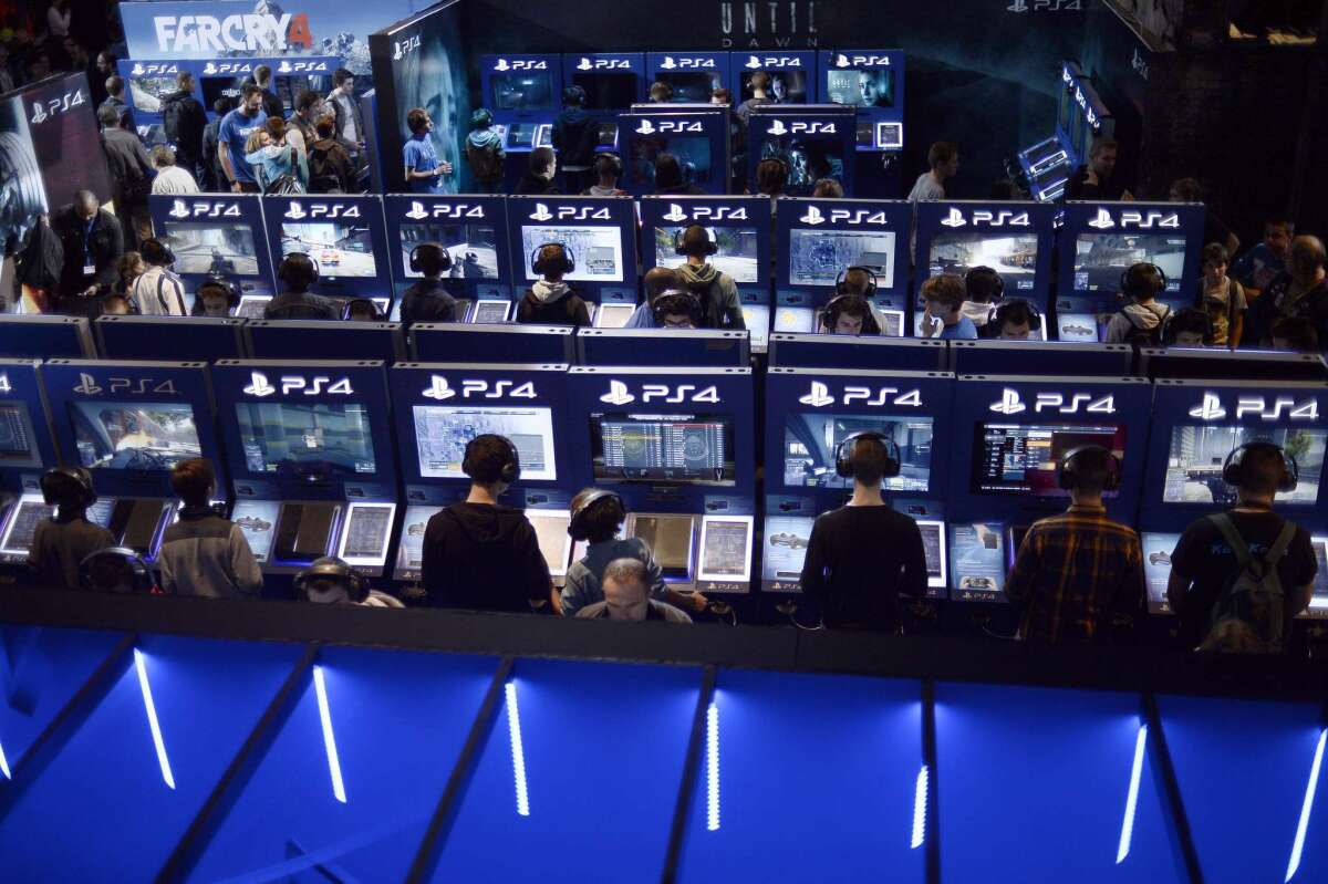 An 18-year-old man in northwest England was arrested by U.K. police in an investigation linked to the Christmas Day hacking of Microsoft Corp.'s Xbox Live and Sony Corp.'s PlayStation Network Internet services. A file picture taken in October in Paris shows visitors standing at a booth for Playstation 4 as they attend the Paris Games week show.