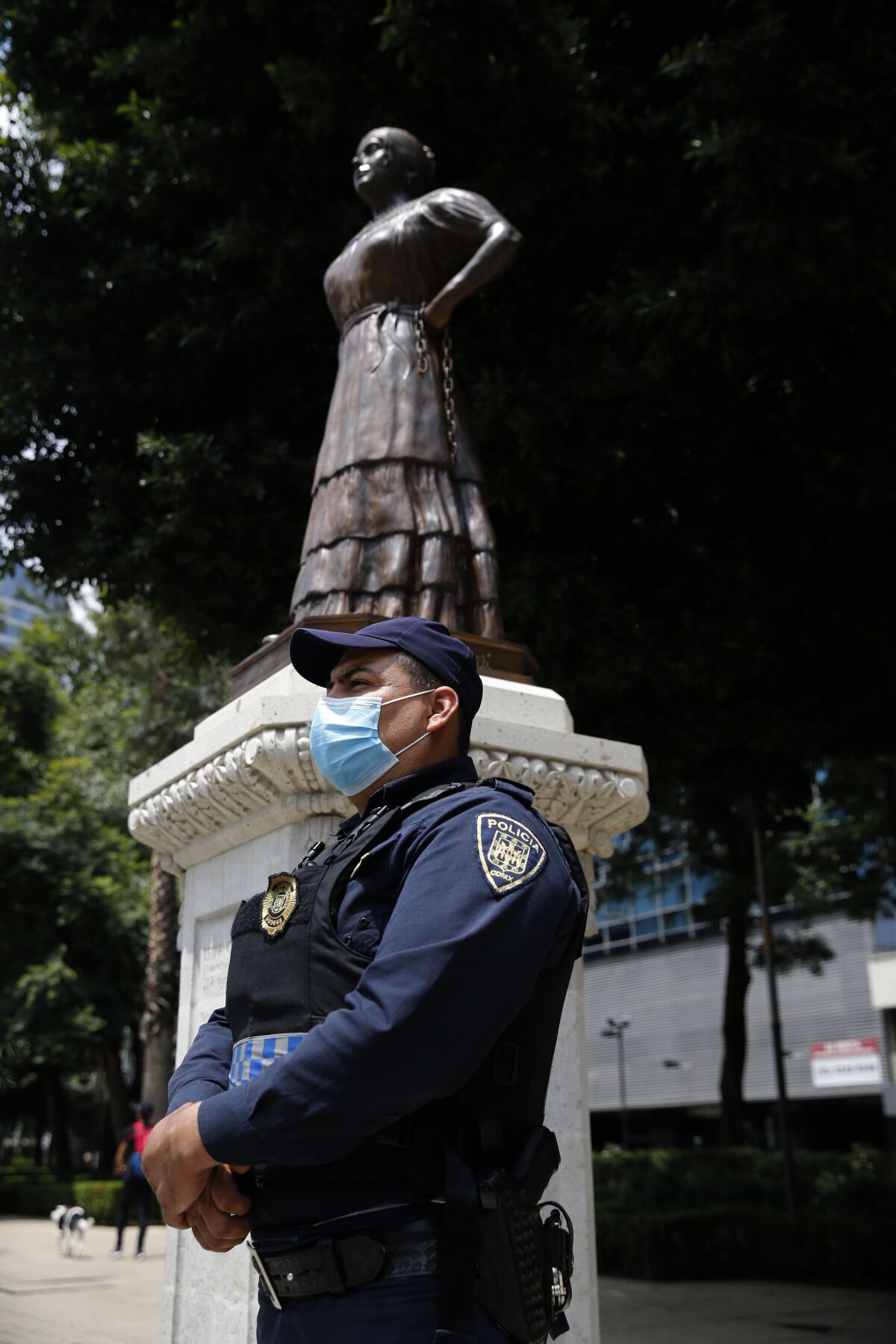 A police officer stands guard near a statue of independence heroine Leona Vicaria on Paseo de la Reforma in Mexico City, Sunday, September 13, 2020. Mexico will celebrate its day of Independence from Spain on September 16. (AP Photo/Marco Ugarte)