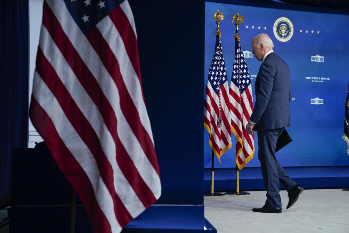 President Biden walks off a stage.