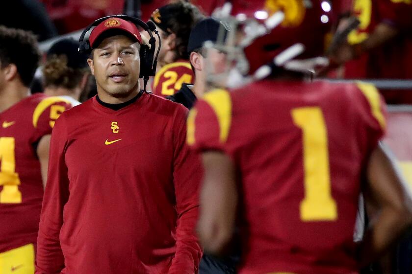 USC interim coach Donte Williams talks with players on the sideline during the Trojans' game against Utah 