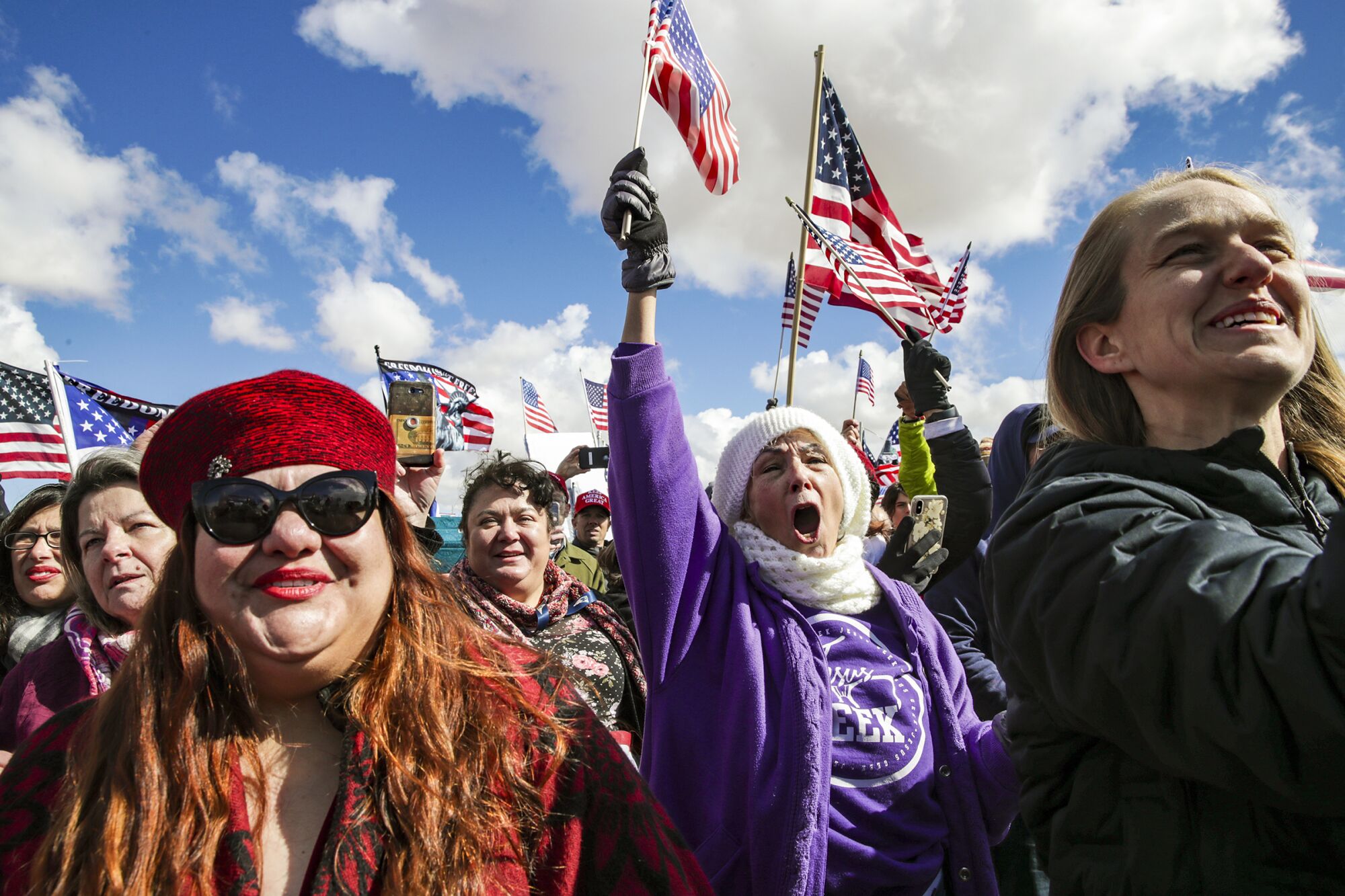 People cheer and wave American flags