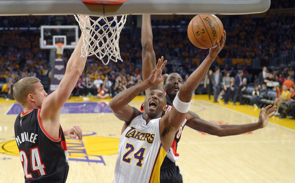 Lakers guard Kobe Bryant shoots as Trail Blazers center Mason Plumlee, left, and forward Al-Farouq Aminu try to defend him during the first half.