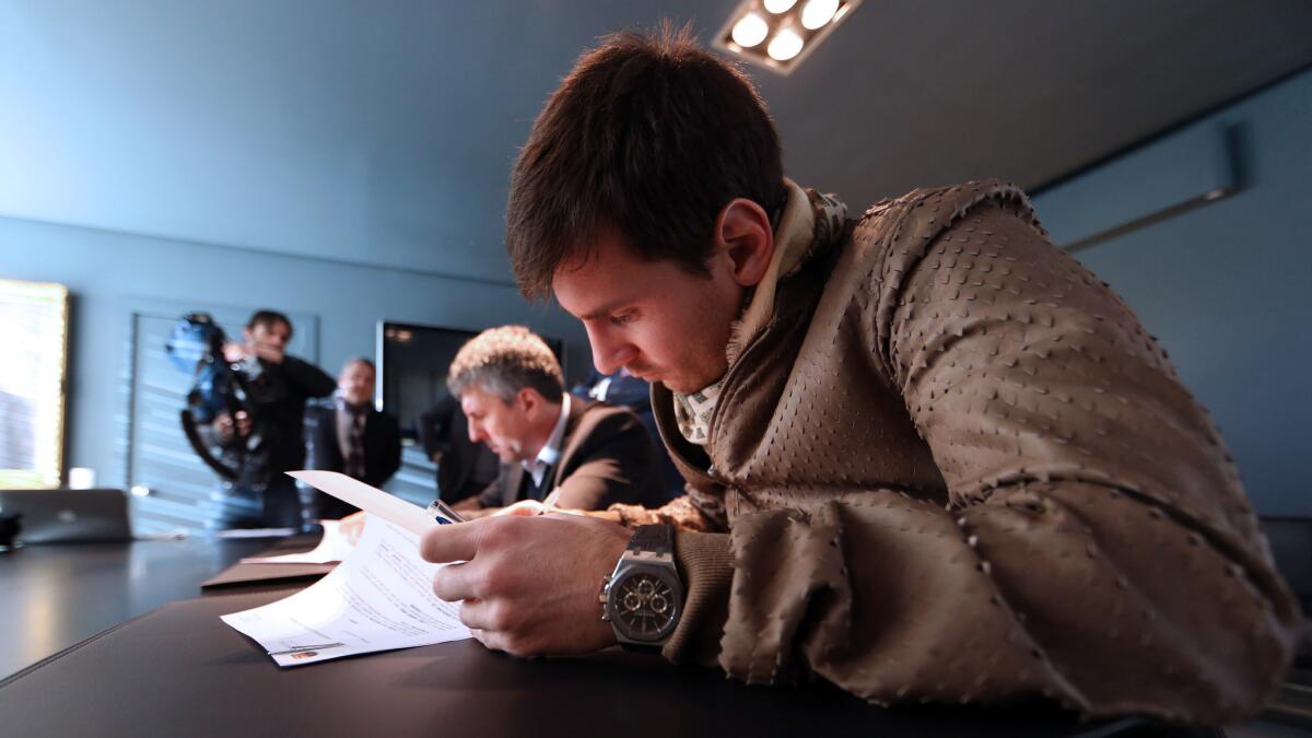 Lionel Messi puts pen to paper as he signs a two-year contract extension that will keep him with FC Barcelona through 2018.