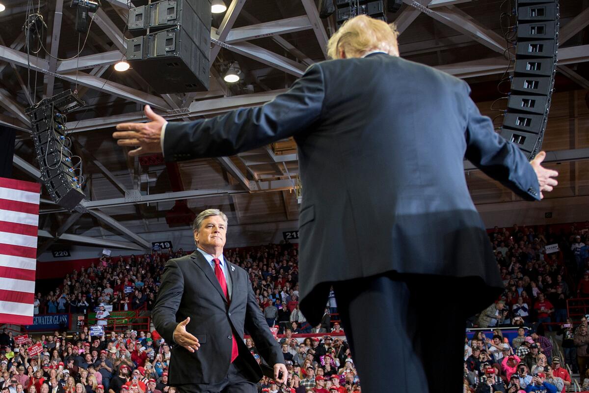 US President Donald Trump greets talk show host Sean Hannity 