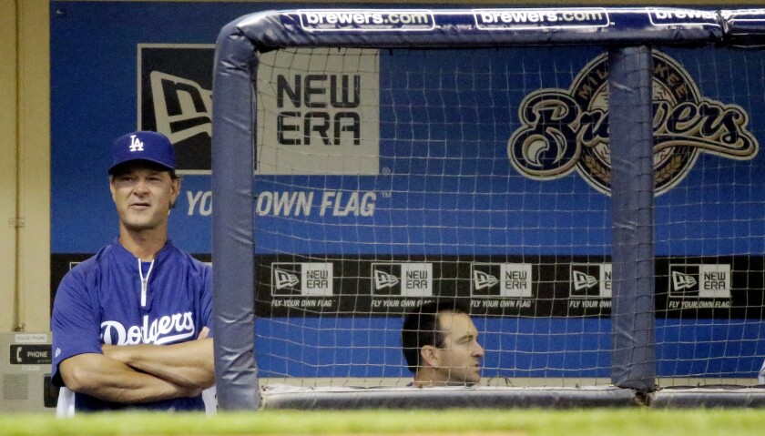Dodgers manager Don Mattingly watches from the dugout during the first inning of a game against the Milwaukee Brewers.