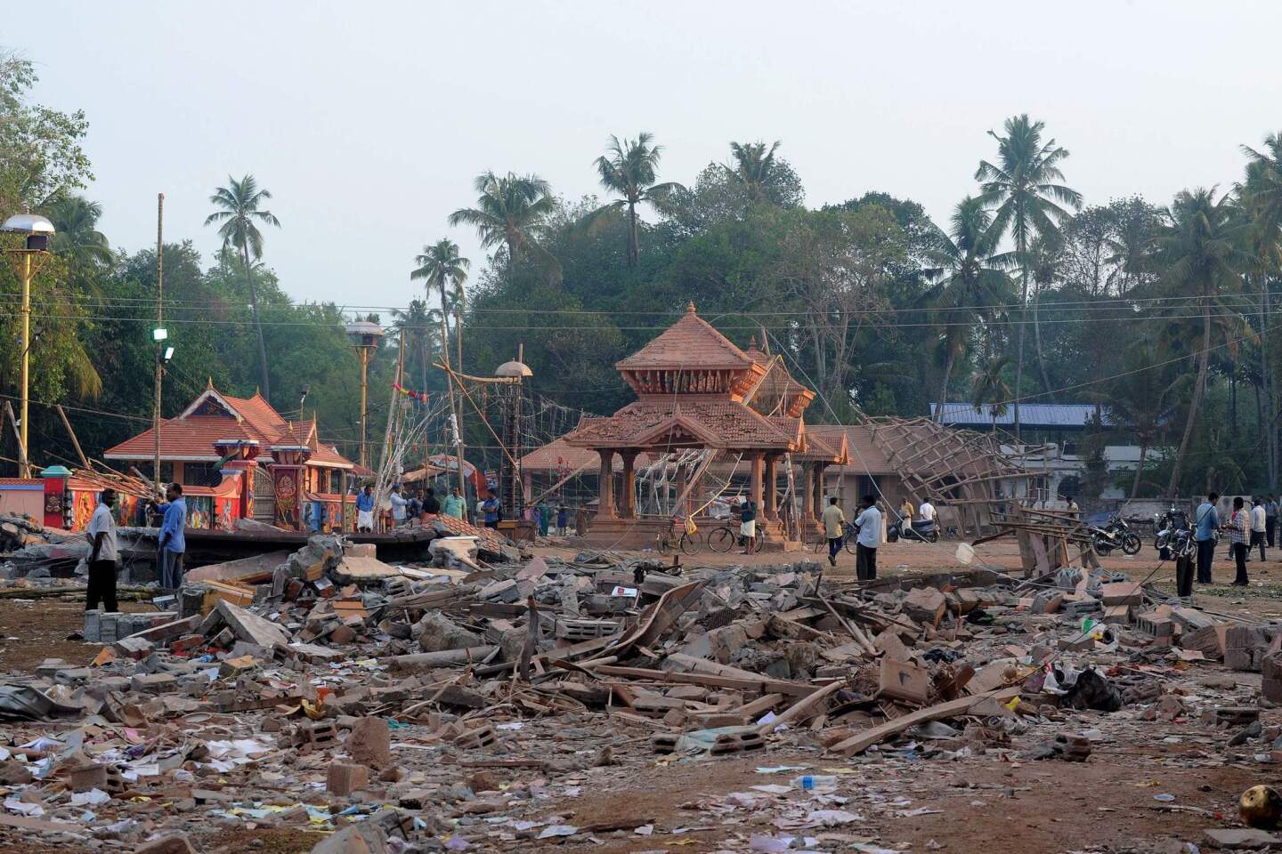 Indian bystanders gather among debris and building wreckage of The Puttingal Devi Temple in Paravur, India, on April 11, 2016.