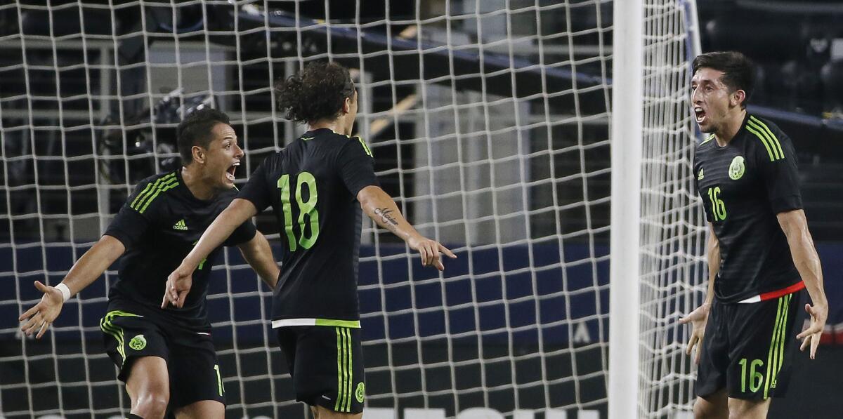 Javier Hernández (i) y Andrés Guardado (c) felicitan a Héctor Herrera, por su gol en el amistoso ante Argentina en el AT&T Stadium de Arlington, Texas.