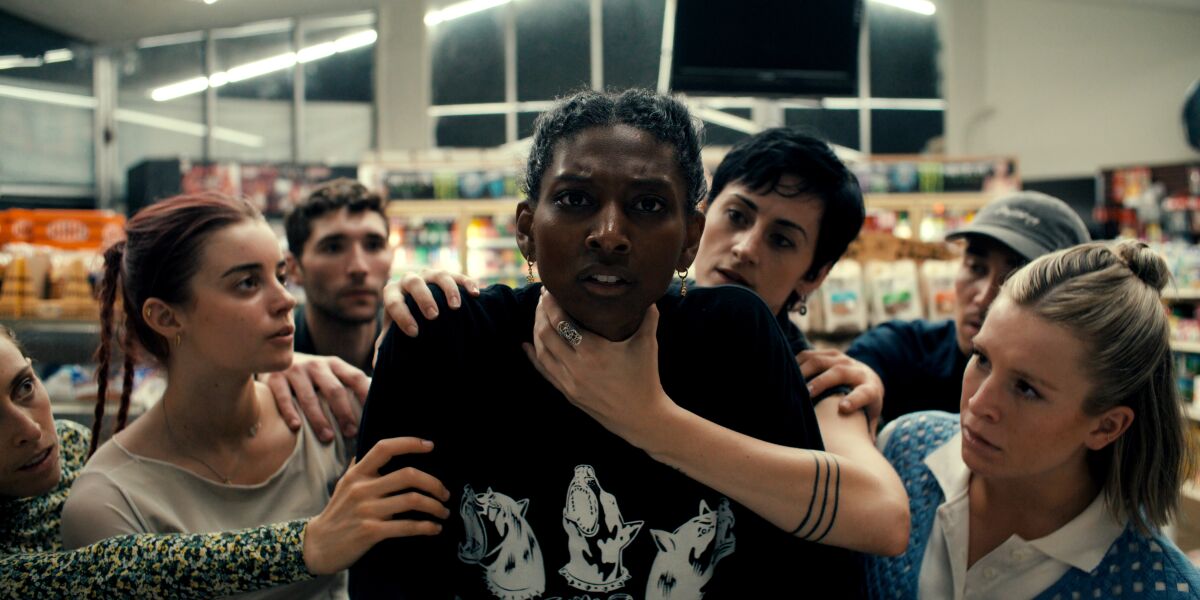 Micaela Taylor appears to be getting choked at the grocery store in a still from "MisFit."