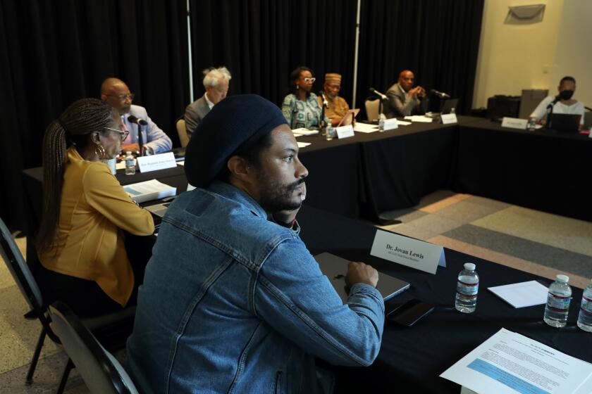 Dr. Jovan Lewis, center, listens during as the California Reparations Task Force.