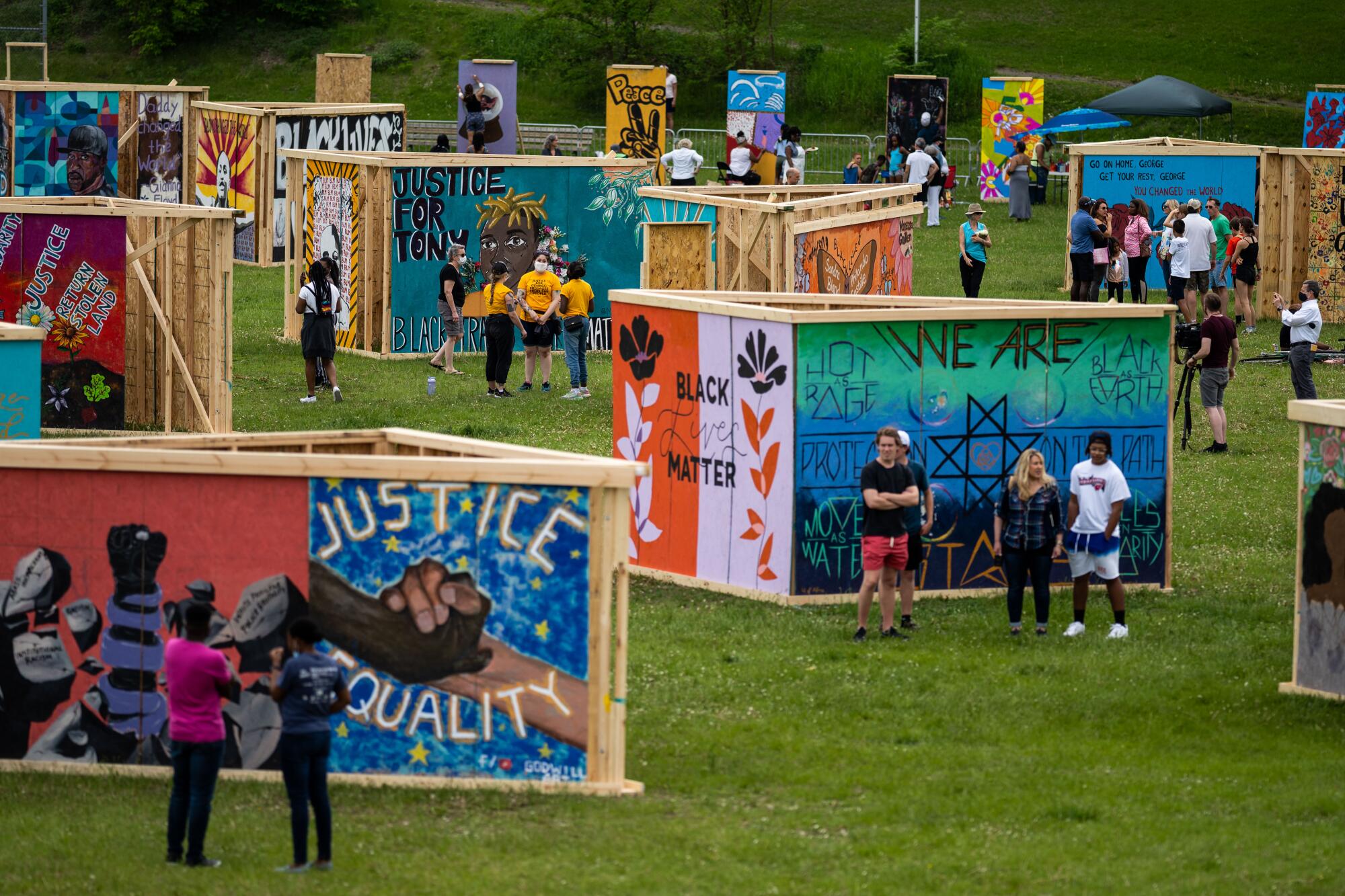 People walk through an exhibit in a park.