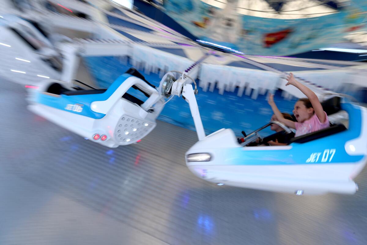 Stella, 10, and Luke, 11, cheer as Ice Jet takes them on a very fast circular trip at the OC Fair.