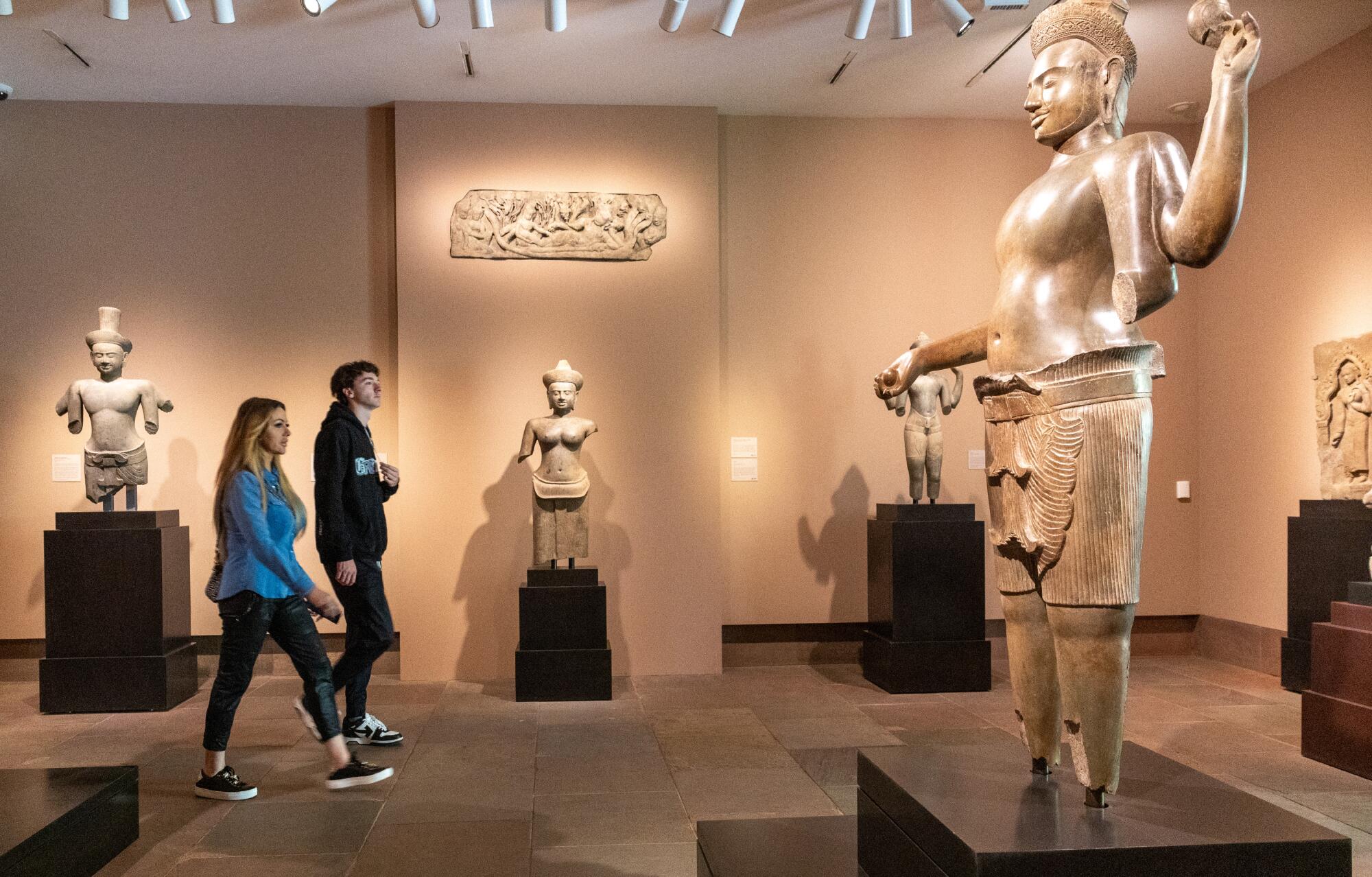 Museum goers walk through exhibit with the Lintel with Reclining Vishnu and Retinue, top,
