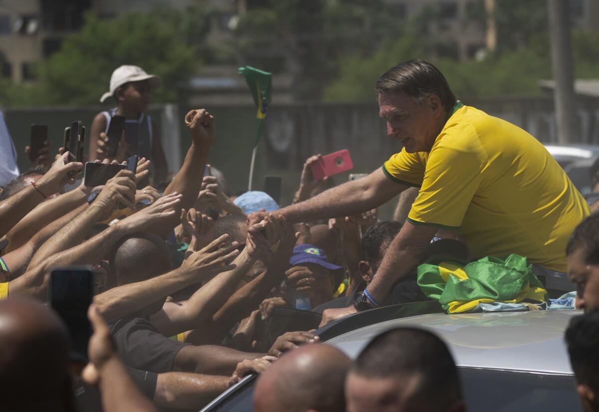 El expresidente brasileño Jair Bolsonaro saluda a sus partidarios en un acto de campaña 