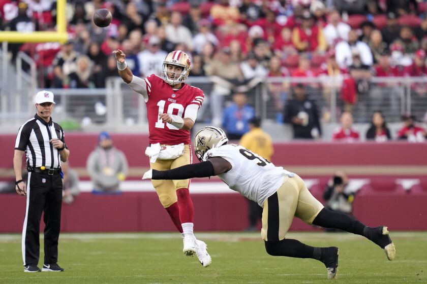 El quarterback de los 49ers de San Francisco Jimmy Garoppolo (10) lanza el balón mientras lo intenta capturar el defensive end Malcolm Roach en el encuentro del domingo 27 de noviembre del 2022. (AP Foto/Godofredo A. Vásquez)