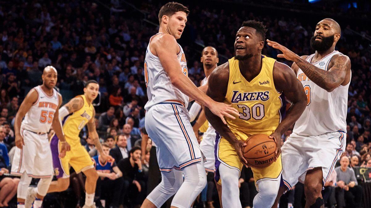 Lakers' Julius Randle, center, drives to the basket against New York Knicks' Doug McDermott, left, and Kyle O'Quinn, center right, during the first half on Tuesday.
