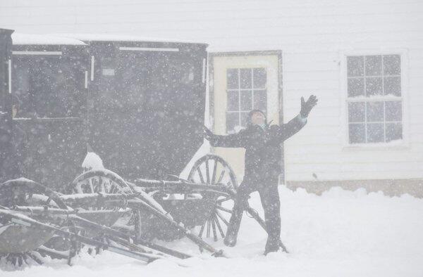 An Amish boy plays in snow outside a one-room schoolhouse in Kingston, Wis.