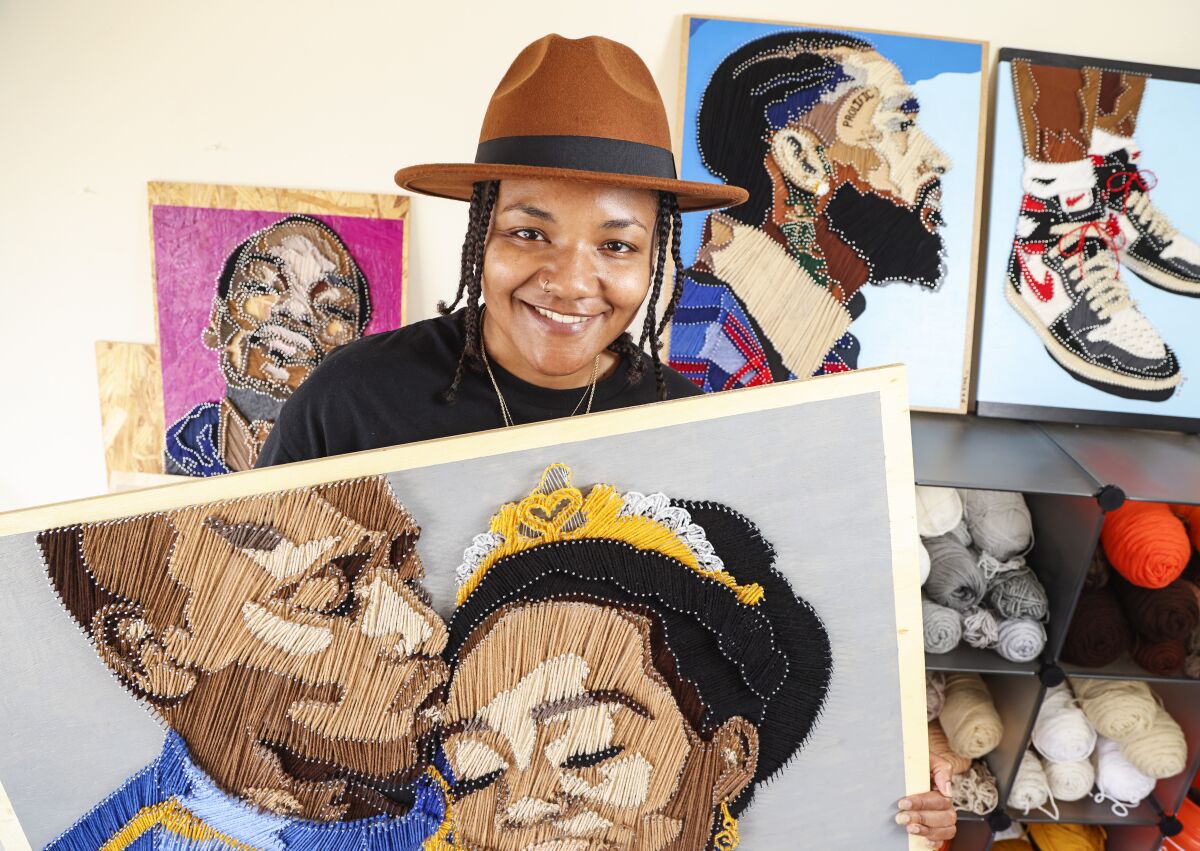Yarn artist Domonique King poses with some of her work