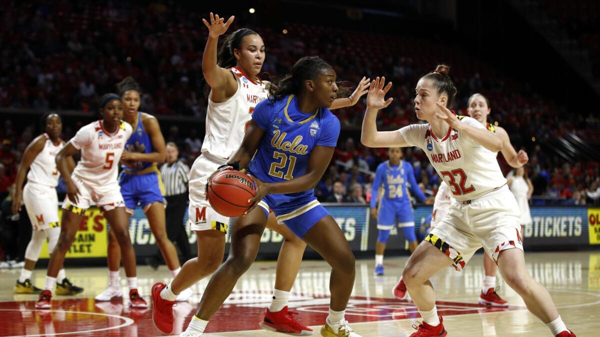 UCLA forward Michaela Onyenwere (21) looks to pass the ball as she is pressured by Maryland guard Sara Vujacic, right, and forward Stephanie Jones during the first half.