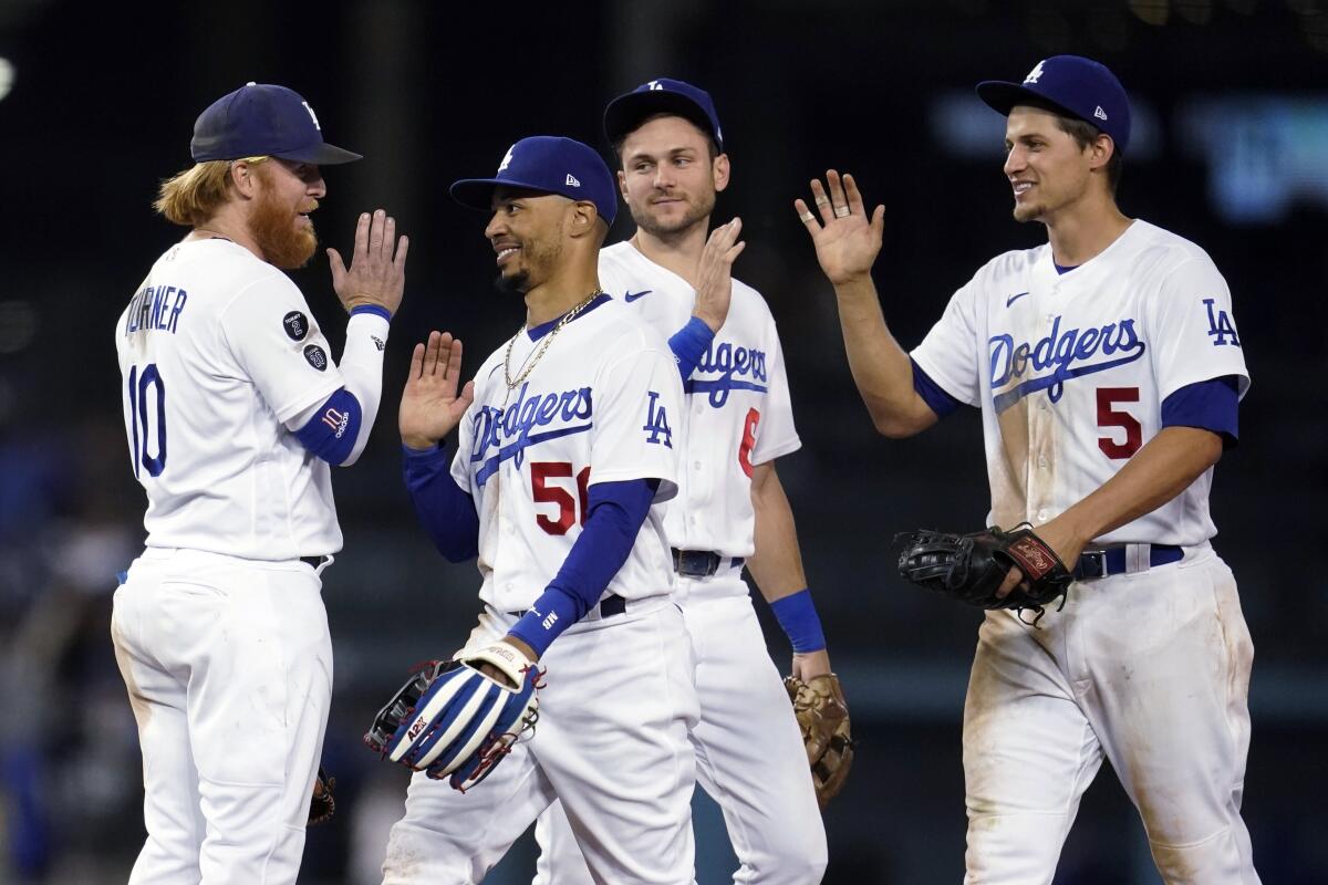 Dodgers teammates (from left) Justin Turner, Mookie Betts, Trea Turner and Corey Seager celebrate an 8-4 victory.