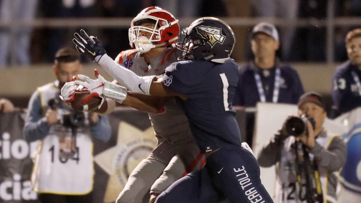 Mater Dei wide receiver Bru McCoy makes a key catch against St. John Bosco defender Chris Steele in the second quarter Nov. 23 at Cerritos College. Both McCoy and Steele are former USC commits.