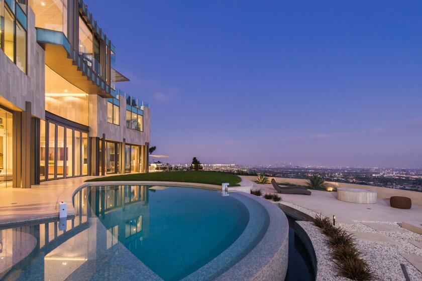 The Richard Landry-designed home in Hollywood Hills West features walls of glass, a three-story staircase and an infinity-edge swimming pool.