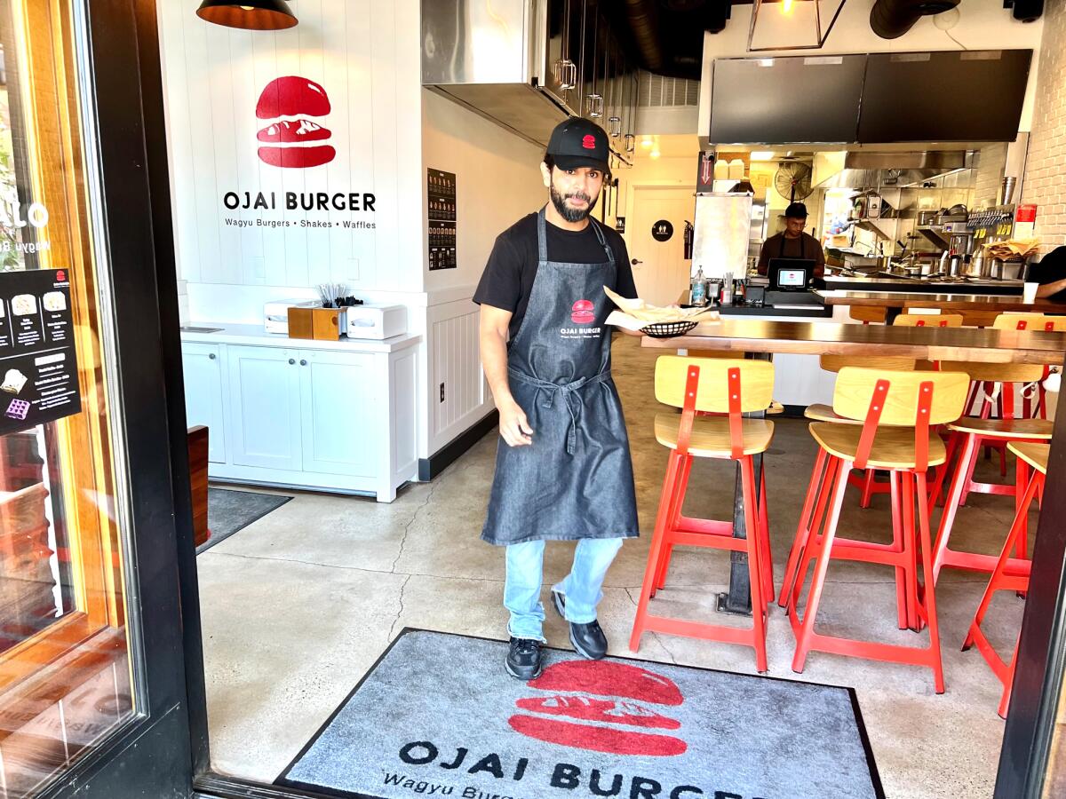 A server stands inside the door at a new Ojai Burger in Orange.