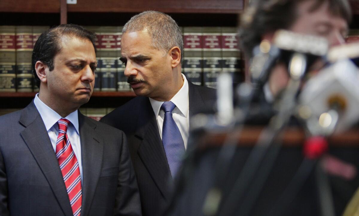 U.S. Attorney for New York's Southern District Preet Bharara confers with U.S. Attorney General Eric Holder at a news conference in 2011. Bharara sent a federal grand jury subpoena to Reason.com demanding "all identifying information" about six anonymous users who posted comments on the site.