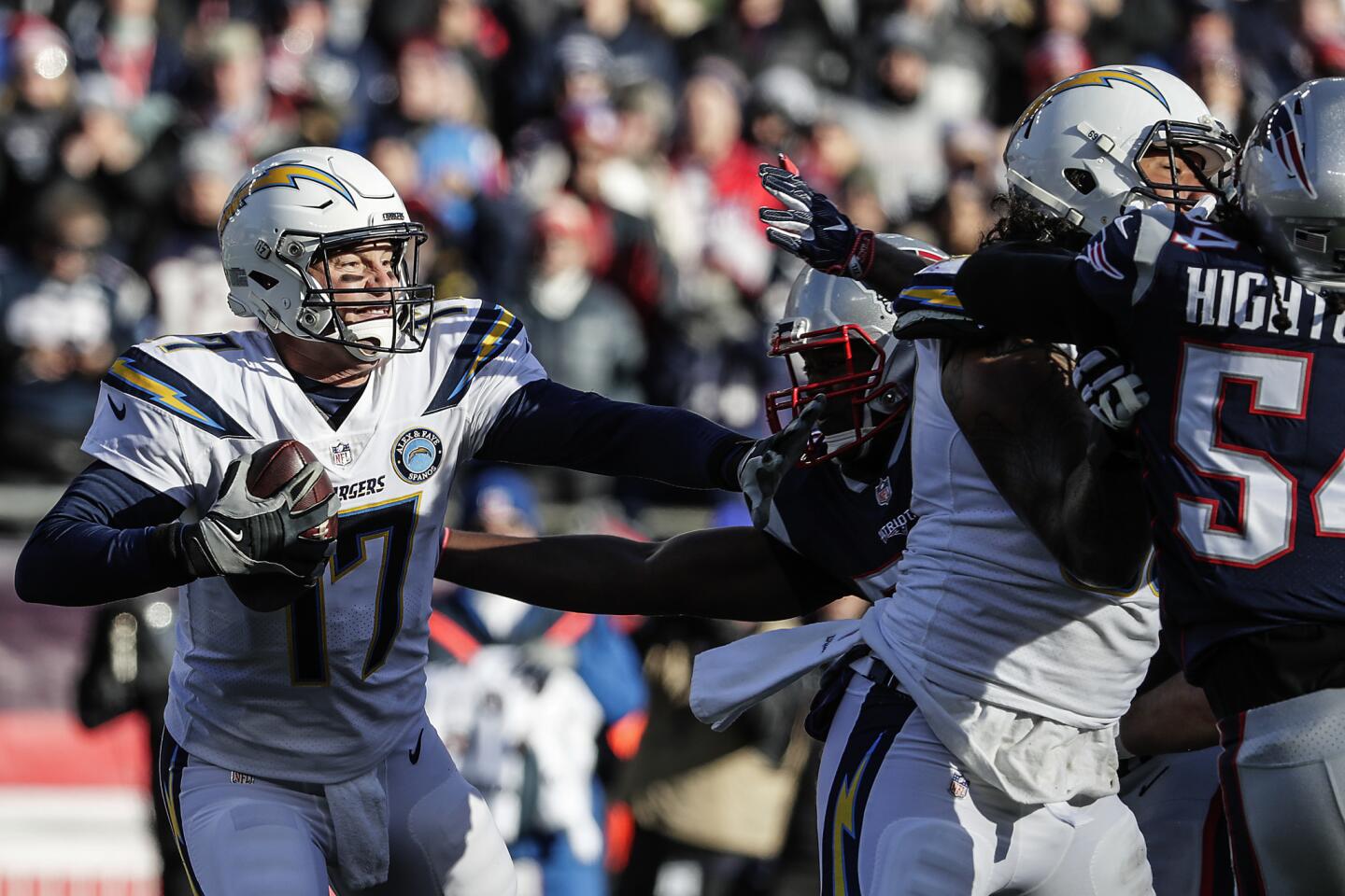 Chargers quarterback Philip Rivers struggles to escape pressure from New England Patriots defenders during first half action in the NFL AFC Divisional Playoff at Gillette Stadium.