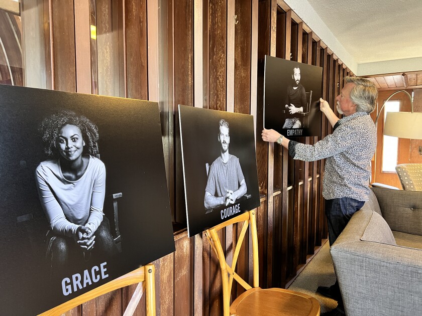 La Jolla Christian Fellowship's Jeffery Edwards prepares photos of church members for the "Unity Project" exhibit.
