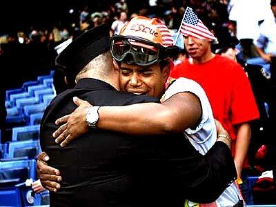 Twin towers rescue worker Miguel Gomez and a New York police officer embrace after a prayer service at Yankee Stadium.
