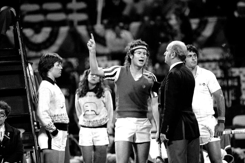 John McEnroe gesture angrily in 1980 as he argues call with umpire Joey Lessing and head referee Fred Hoyles