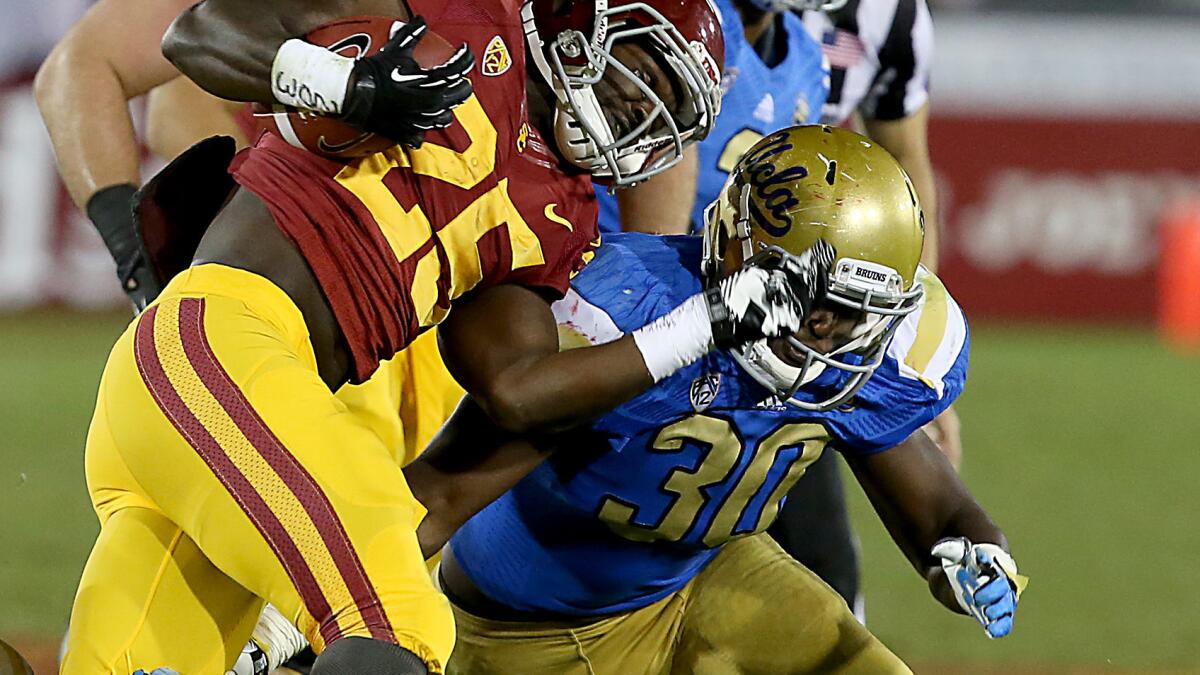 UCLA linebacker Myles Jack, right, puts a hit on USC tailback Silas Redd during the Bruins' win in November. Jack likely will play an even bigger role on defense for UCLA this season.