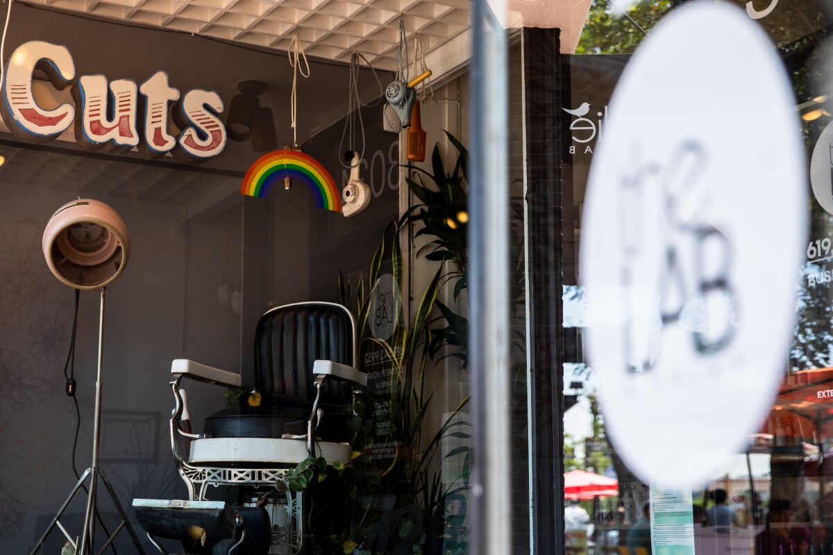 A rainbow decal is seen posted on the front window of The Lab A Salon in North Park on Wednesday, June 30.