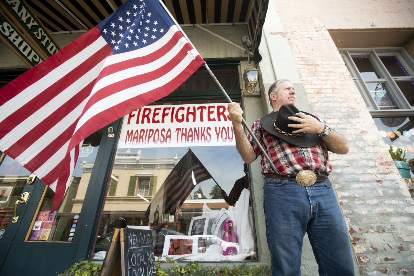 Charles Phillips waits for a procession carrying the body of firefighter Braden Varney in Mariposa, Calif. Varney died Saturday while battling the Ferguson fire when his bulldozer overturned.