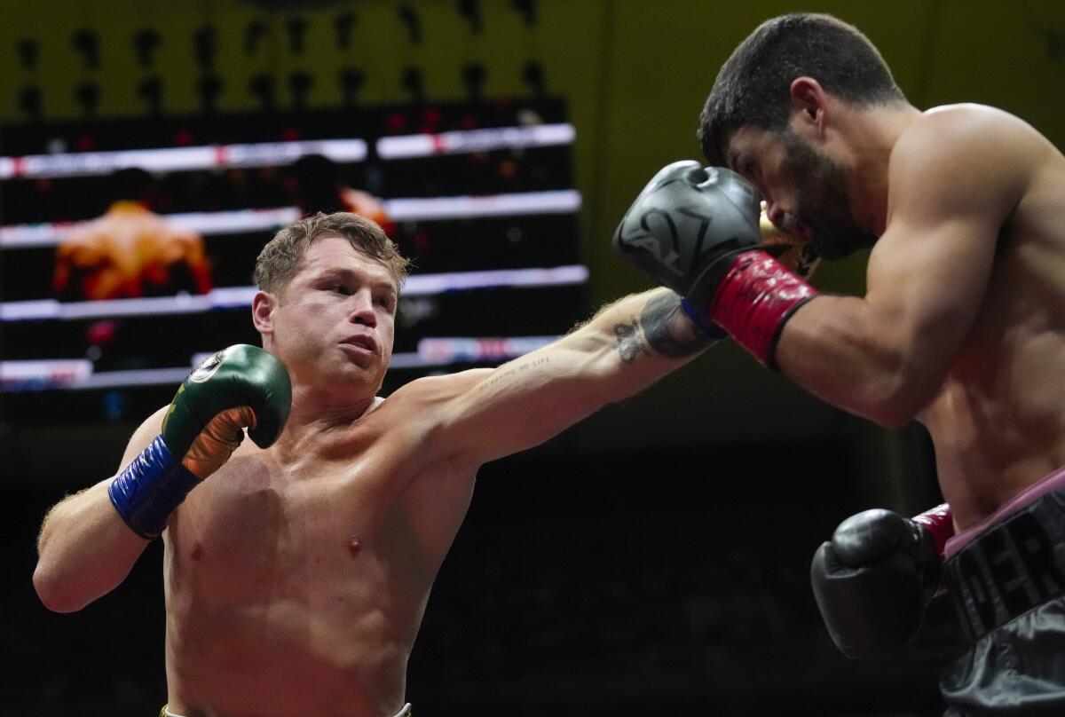Canelo lvarez, left, jabs John Ryder in the head during their super middleweight title fight on May 6.