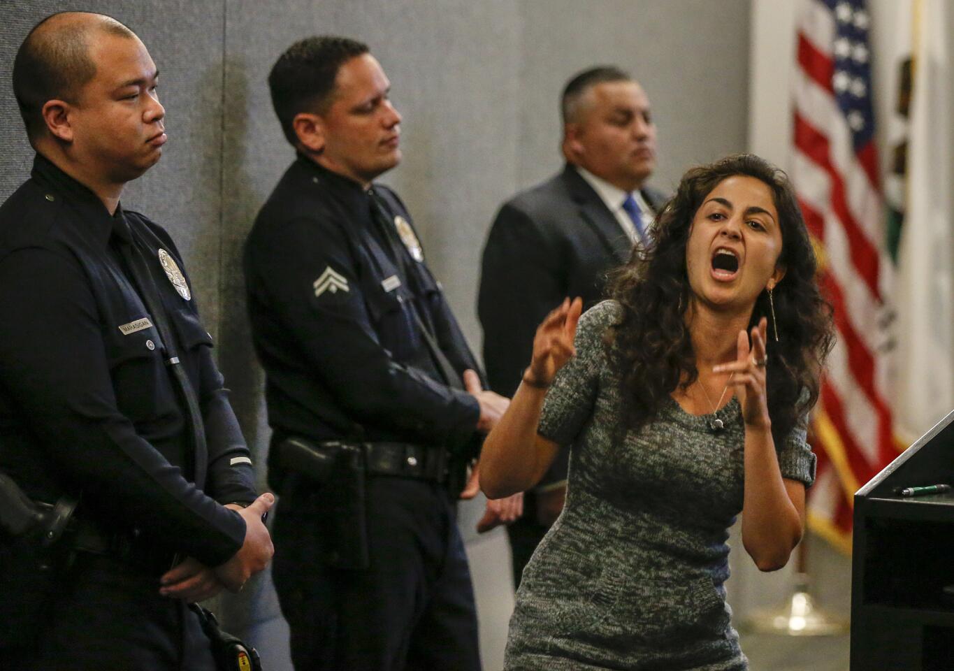 Mariella Saba gestures near several officers during her two minutes of public comment before the vote by the Los Angeles Police Commission to adopt new LAPD rules for use of deadly force.