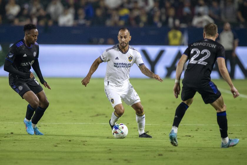 LA Galaxy midfielder Victor Vazquez, center, controls the ball between CF Montreal forward Mason Toye, left, and defender Alistair Johnston, right, during the second half of an MLS soccer match in Carson, Calif., Monday, July 4, 2022. (AP Photo/Alex Gallardo)