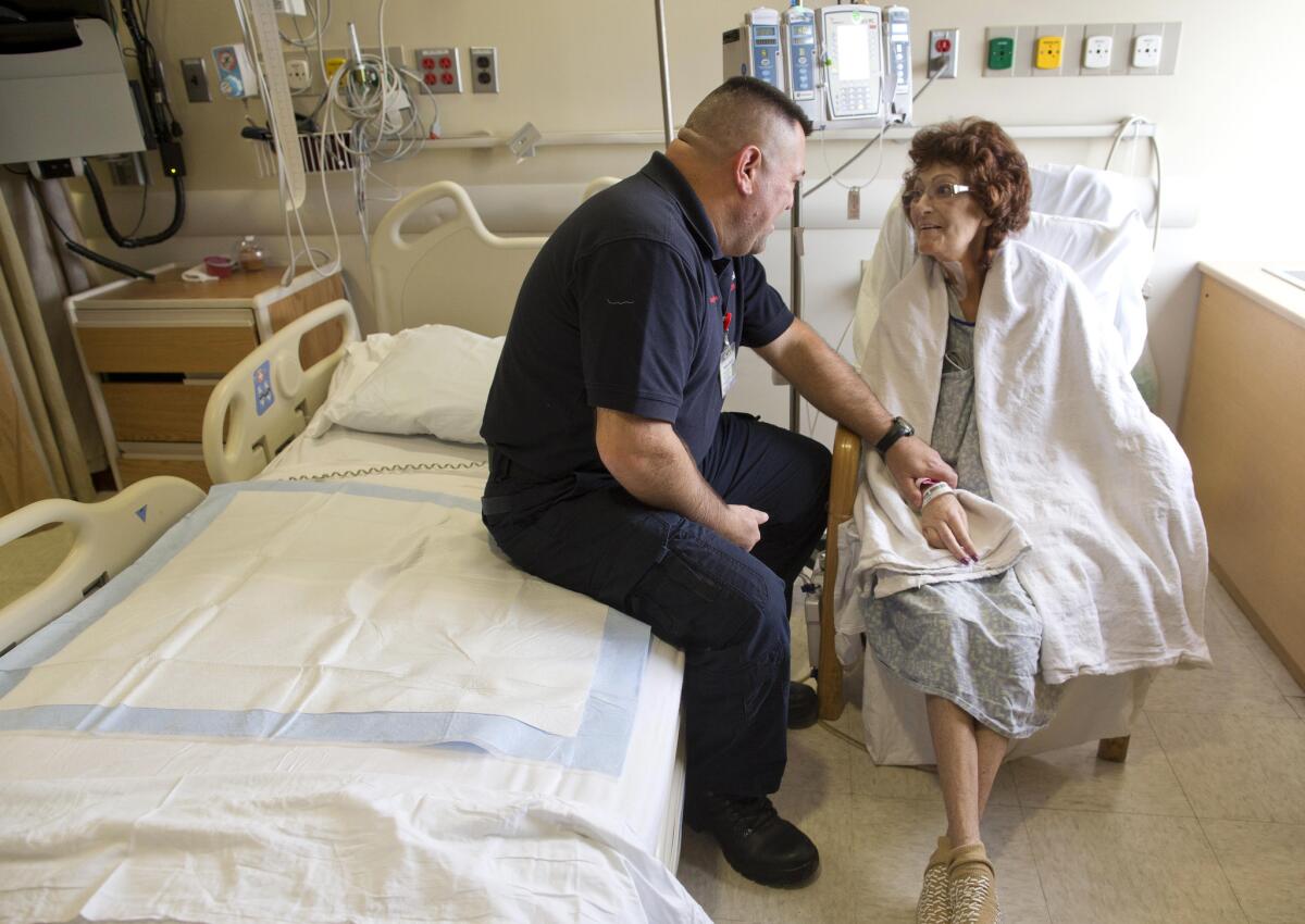 El paramédico Pete Amato, izquierda, platica con la paciente del hospital Stony Brook University, Melanie Chirichella, en su habitación, en Stony Brook, Nueva York. Amato manejó en medio de la tormenta de nieve el sábado para trasladar casi 32 kilómetros a Chirichella desde su casa hasta el hospital para que recibiera un trasplante de riñón, por el cual había esperado casi año y medio. (Foto AP/Julie Jacobson)