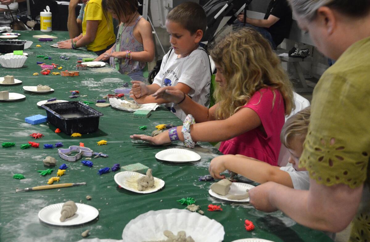 Kids create clay fossils as part of Art Steps section during Imaginology at the OC Fair & Events Center Saturday.