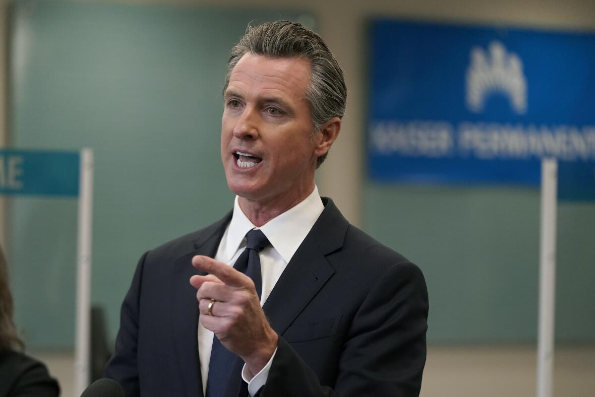 Gov. Gavin Newsom points his finger as he speaks at a news conference in Oakland