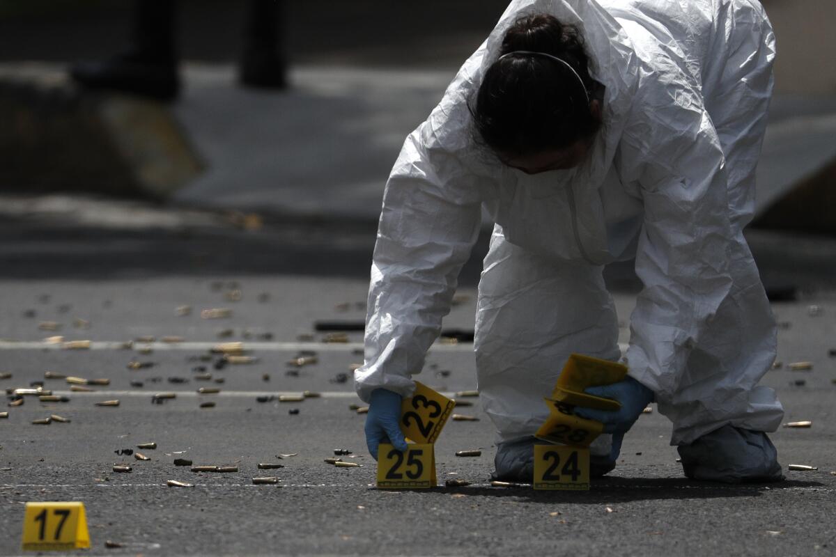 Personal forense marca los cartuchos en el lugar donde se registró un atentado contra el secretario de Seguridad Ciudadana