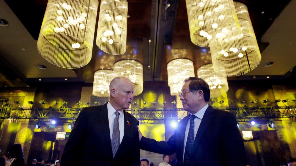 California Gov. Jerry Brown, left, chats with China's science and technology minister Wan Gang as they attend the Clean Energy Ministerial International Forum on Electric Vehicle Pilot Cities and Industrial Development in Beijing in June.