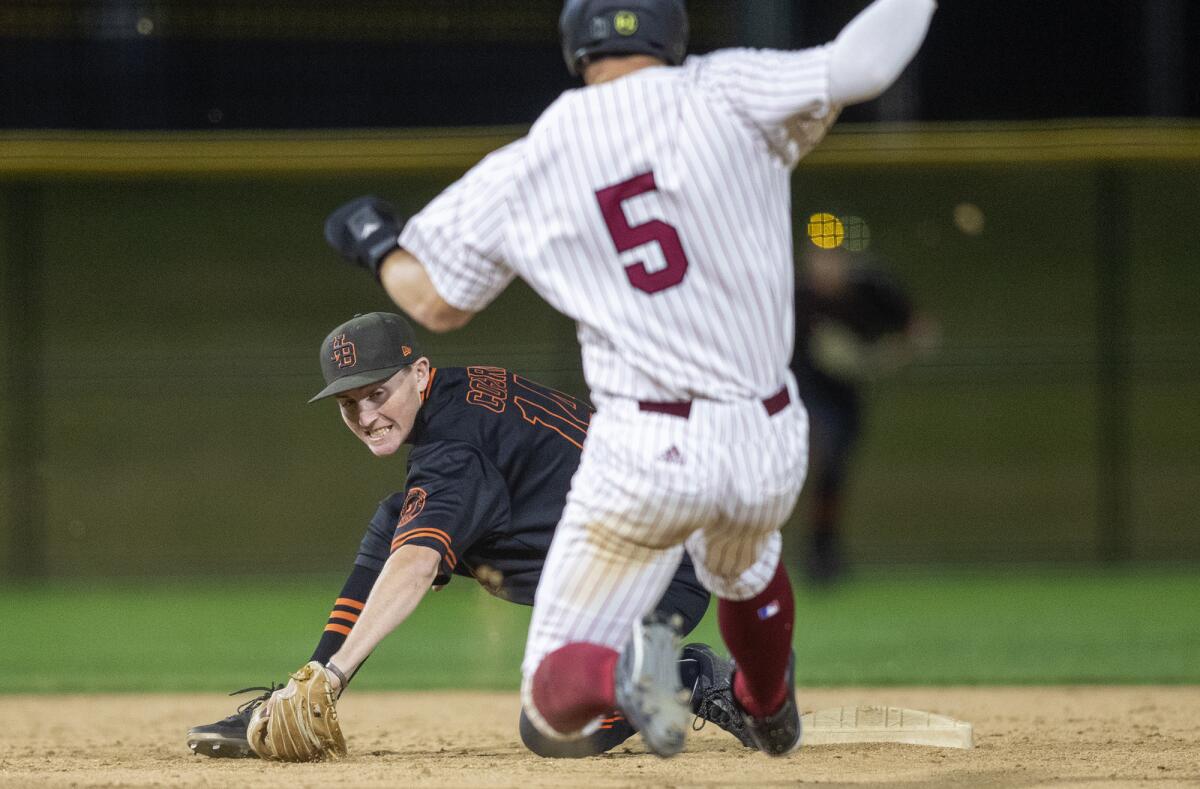 Huntington Beach's Michael Coburn tags out JSerra's Cody Schrier on a stolen-base attempt during the Newport Elks Tournament Frank Lerner Division title game at Orange County Great Park in Irvine on Friday.