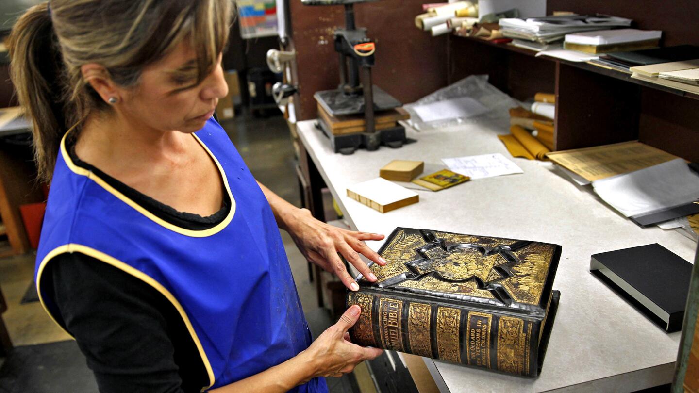 Restoration specialist Grace Sanchez the cover of a family Bible for a client at Kater-Crafts, a family-run bookbinding company in Pico Rivera.