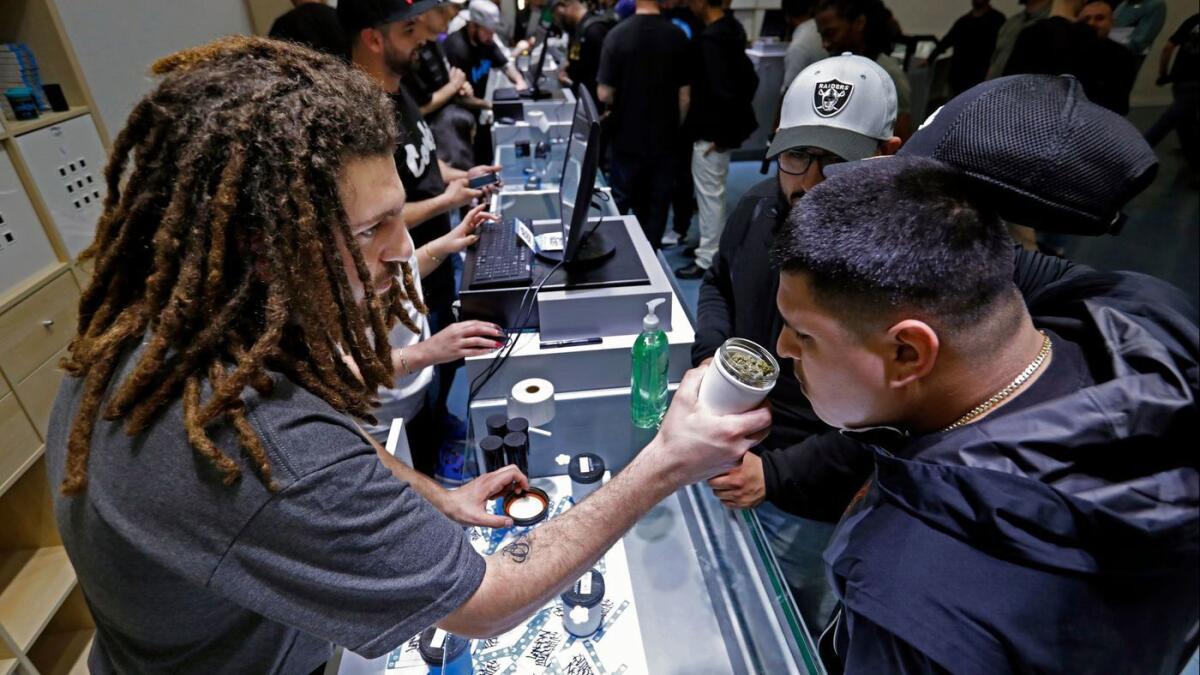 Shant Damirdjian, left, assists customers at Cookies Los Angeles, which sells recreational marijuana under Proposition 64.