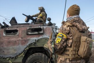 Ukrainian soldiers inspect a damaged military vehicle after fighting in Kharkiv, Ukraine, Sunday, Feb. 27, 2022. The city authorities said that Ukrainian forces engaged in fighting with Russian troops that entered the country's second-largest city on Sunday. (AP Photo/Marienko Andrew)