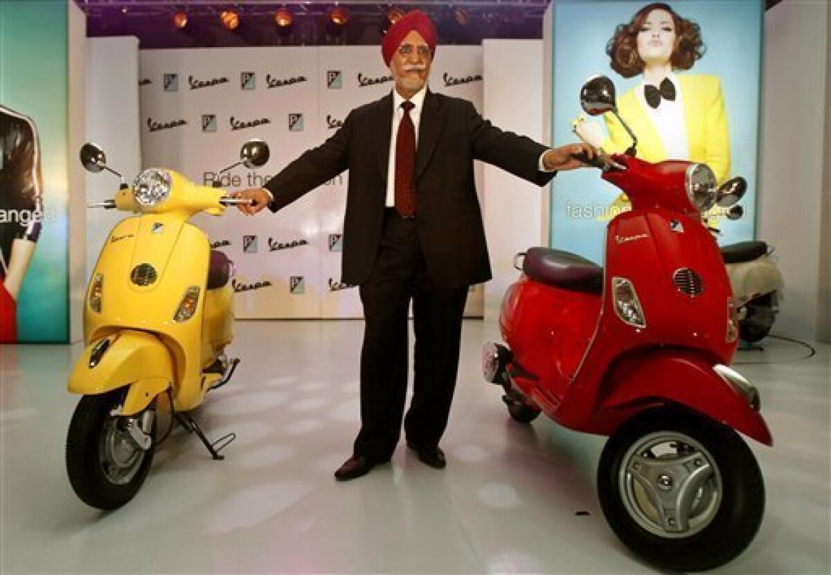 Chairman and Managing Director of Piaggio Vehicles Limited India Ravi Chopra poses with Vespa scooters during their launch in Mumbai, India, Thursday, April 26, 2012. The Italian company hopes to carve out a market for luxury scooters in one of the most cost-conscious markets in the world. The Vespa LX will cost around 66,661 rupees ($1,282) in India, a 40 percent premium to most scooters, but still the lowest sticker price in the world. (AP Photo/Rafiq Maqbool)