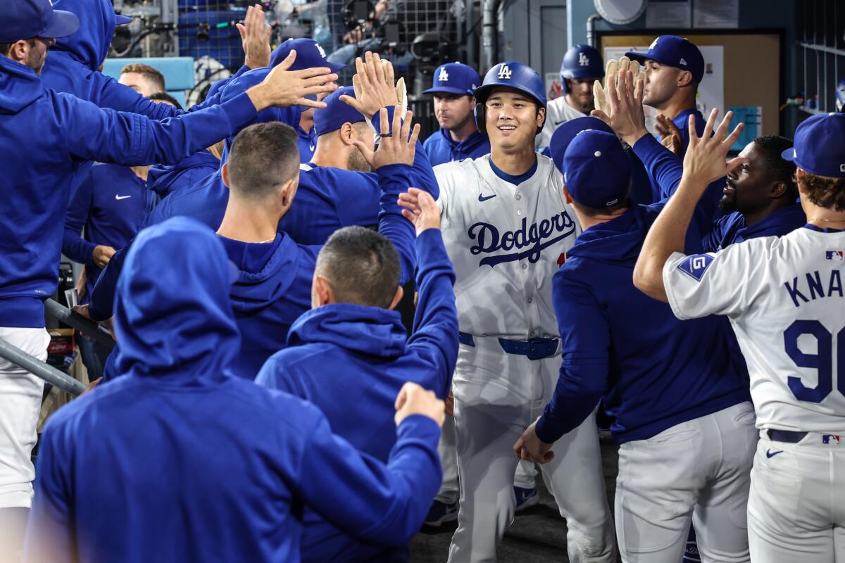 El bateador designado de los Dodgers, Shohei Ohtani, celebra en el dugout luego de lanzar la primera entrada contra los Padres.