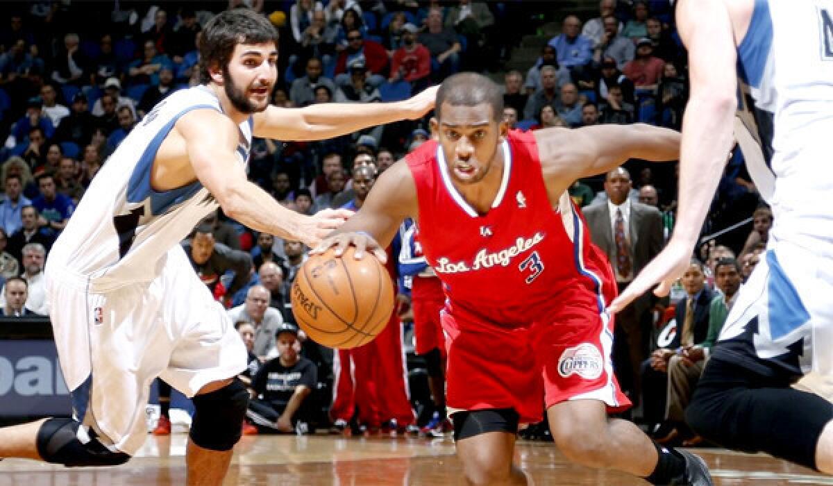 Chris Paul drives toward the hoop in front of Minnesota's Ricky Rubio en route to his 12th consecutive double-double in a win over the Timberwolves, 102-98.